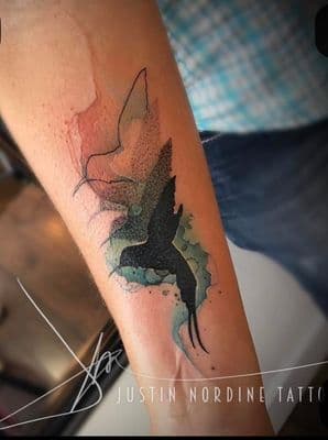 a tattoo of a bird on the arm