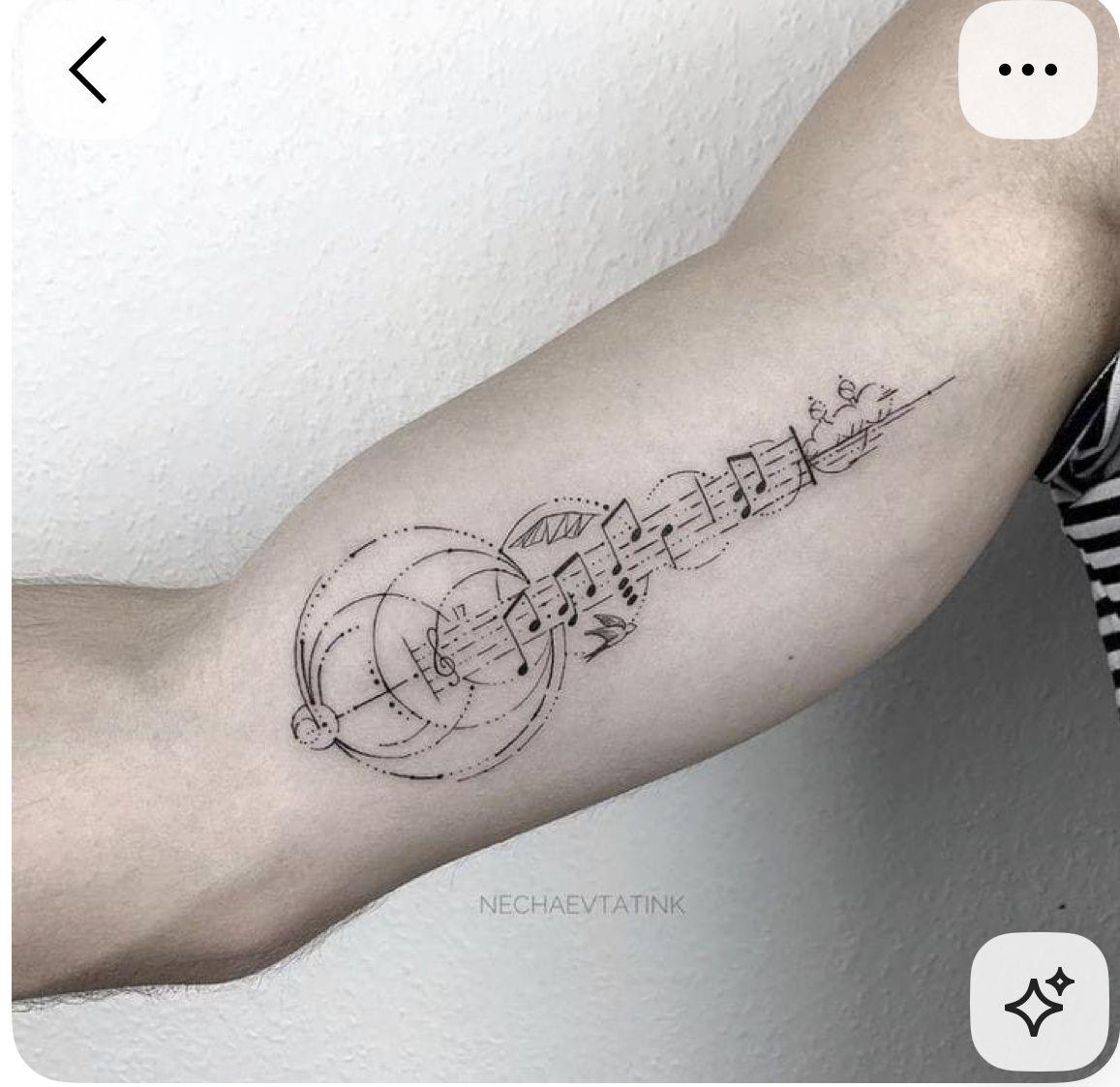 a black and white photo of a person's arm with music notes on it