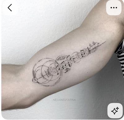 a black and white photo of a person's arm with music notes on it
