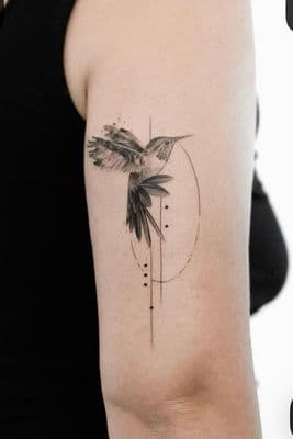 a tattoo of a humming bird on the arm