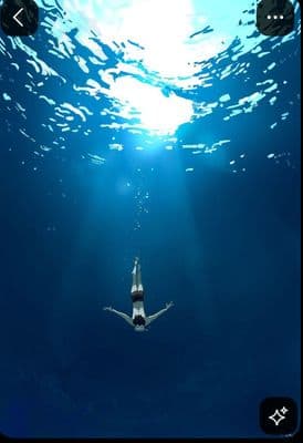 a person floating in the water with their arms outstretched