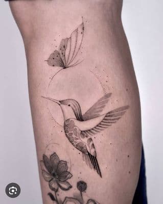a tattoo of a bird and a flower on the side of a woman's