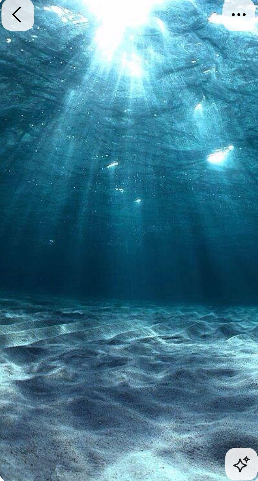 an underwater view of the ocean with sunlight coming through the water