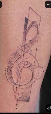 a tattoo of a musical note on the thigh