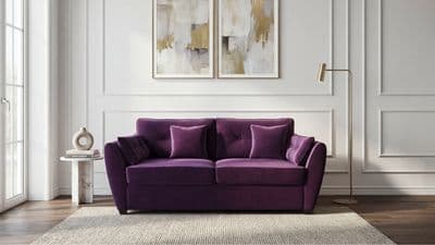 a living room with a purple couch and two paintings on the wall