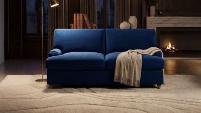 a blue couch sitting in a living room next to a fire place