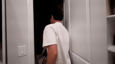 a man in a white shirt standing in a doorway