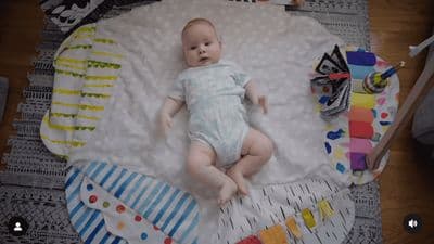 a baby laying on top of a white blanket