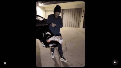 a man standing next to a car in a garage