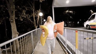 a woman walking down a bridge holding a banana
