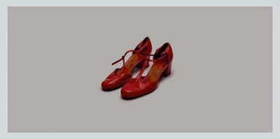 a pair of red shoes sitting on top of a white floor