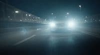 a car driving down a street at night