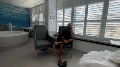 a man sitting in a chair in front of a window