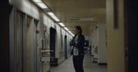a man standing in a hallway next to lockers