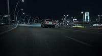 a car driving down a street at night