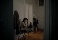 a woman sitting in a chair talking on a cell phone
