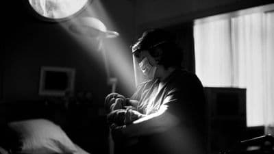 a woman standing in a dark room holding a cell phone