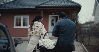 a man and a woman standing outside of a house