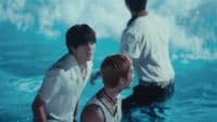 a couple of men standing in the water next to each other