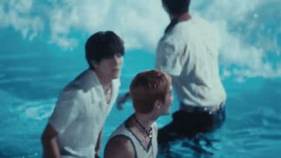 a couple of men standing in the water next to each other