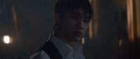 a man in a white shirt and tie standing in the rain