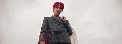 a woman with red hair and a gray jacket
