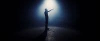 a person standing in the dark holding a light