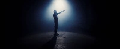 a person standing in the dark holding a light