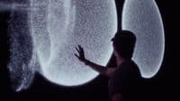a person standing in front of a large screen