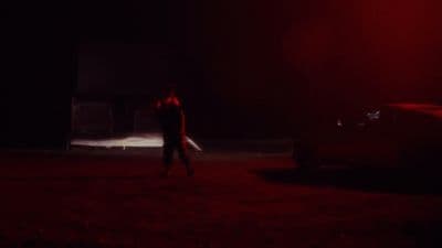 a man standing in the dark with a knife in his hand