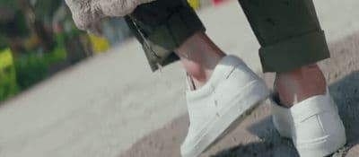 a person wearing white shoes and a furry coat