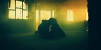 a couple of people kissing in a dark room