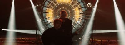 a couple of people standing in front of a ferris wheel