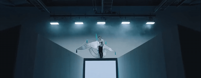 a man standing on top of a tv screen in a dark room