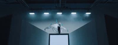a man standing on top of a tv screen in a dark room