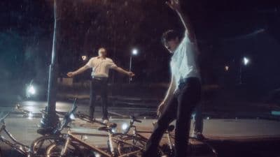 a couple of men riding bikes down a street