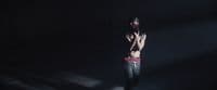 a shirtless man standing in a dark room