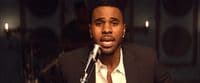 a man in a suit is singing into a microphone