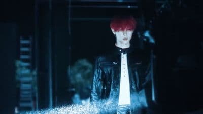 a man with red hair wearing a black jacket and tie