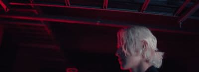 a woman with white hair standing in a dark room