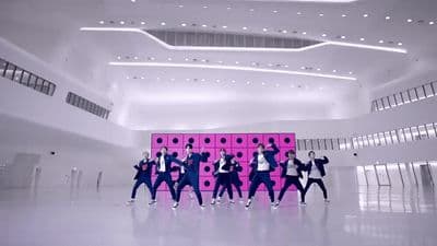 a group of young men standing in front of a pink wall