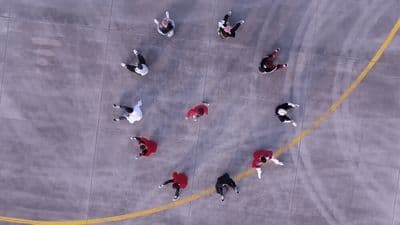 a group of people walking across a parking lot