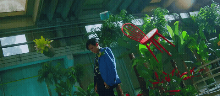 a man standing in front of a bunch of plants