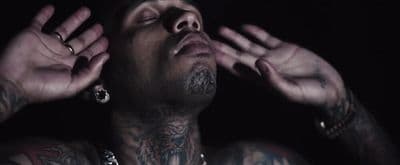 a man with tattoos and piercings on his chest