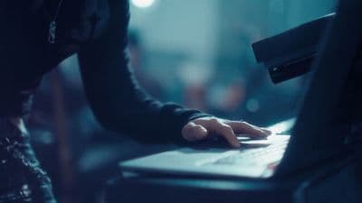 a person typing on a laptop in a dark room
