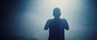 a silhouette of a person standing in front of a light