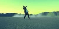 a man riding a skateboard across a desert