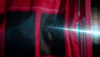 a close up of a red curtain with a light shining through it