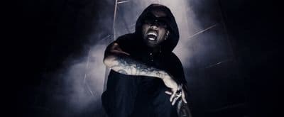 a man in a black hoodie with his mouth open