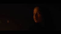 a woman in a dark room with a candle in her hand